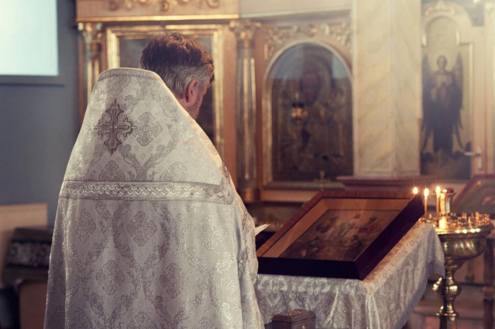 Free Image of Priest facing an Orthodox altar with icons 
