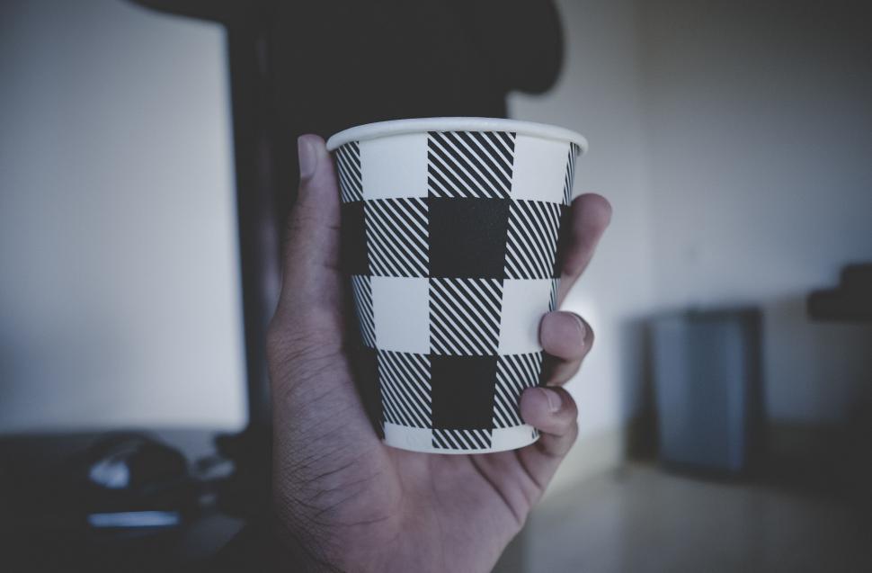 Free Image of Hand holding a patterned paper cup 