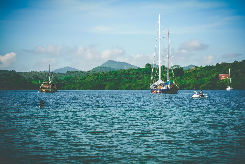 Free Image of Boats on calm water with hills in background 