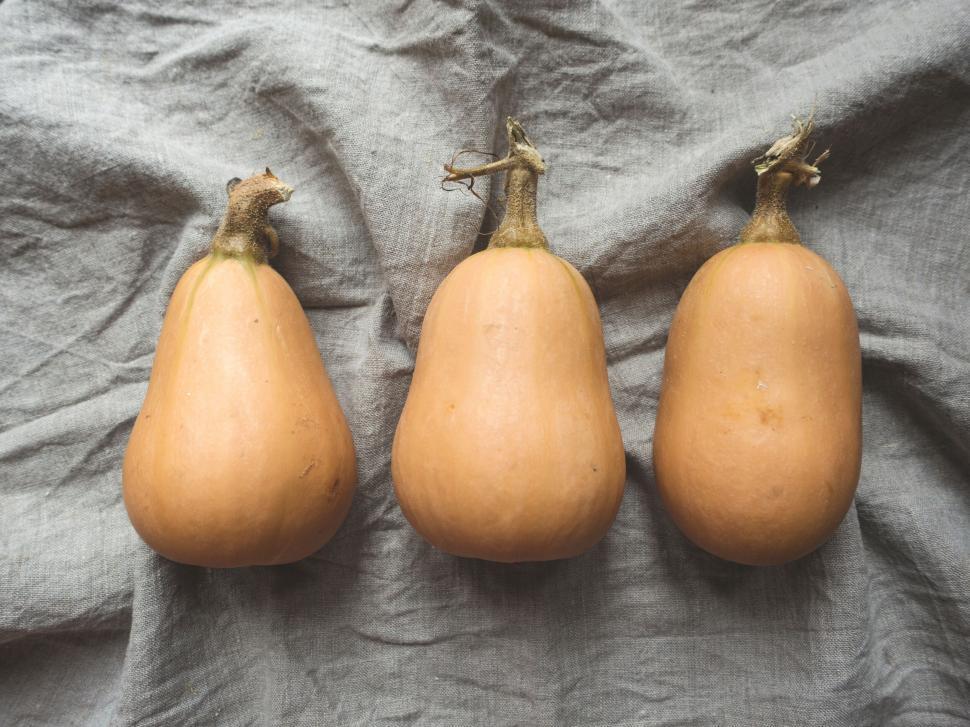 Free Image of Three butternut squashes on fabric background 