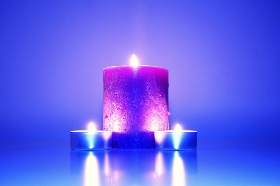 Free Image of Glowing purple candle with tealights 