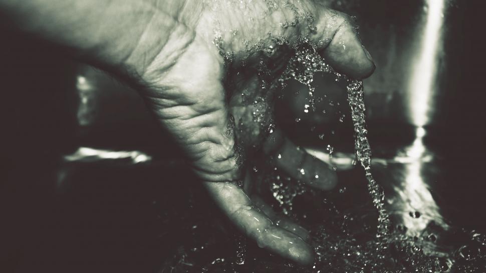 Free Image of Hand under running water in black and white 