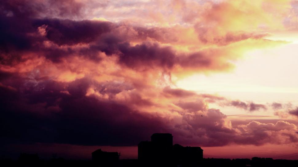 Free Image of Dramatic sunset sky over building silhouettes 