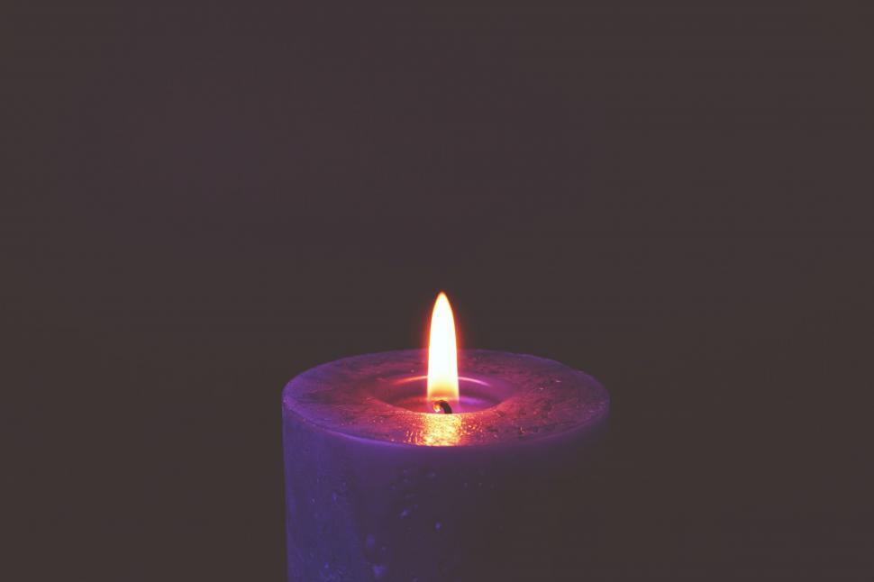 Free Image of Candle with a purple hue in darkness 