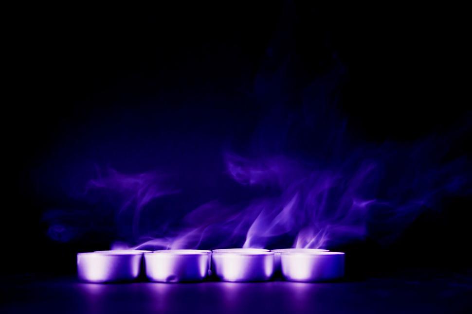 Free Image of Purple smoke rising from candles 