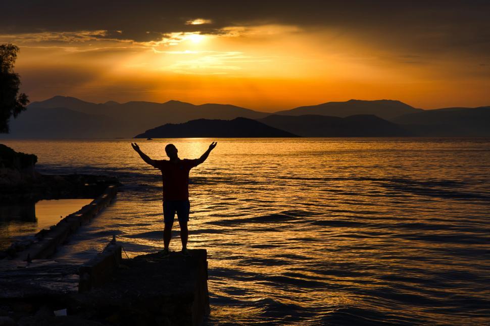 Free Image of Silhouette of a person celebrating by the sea 