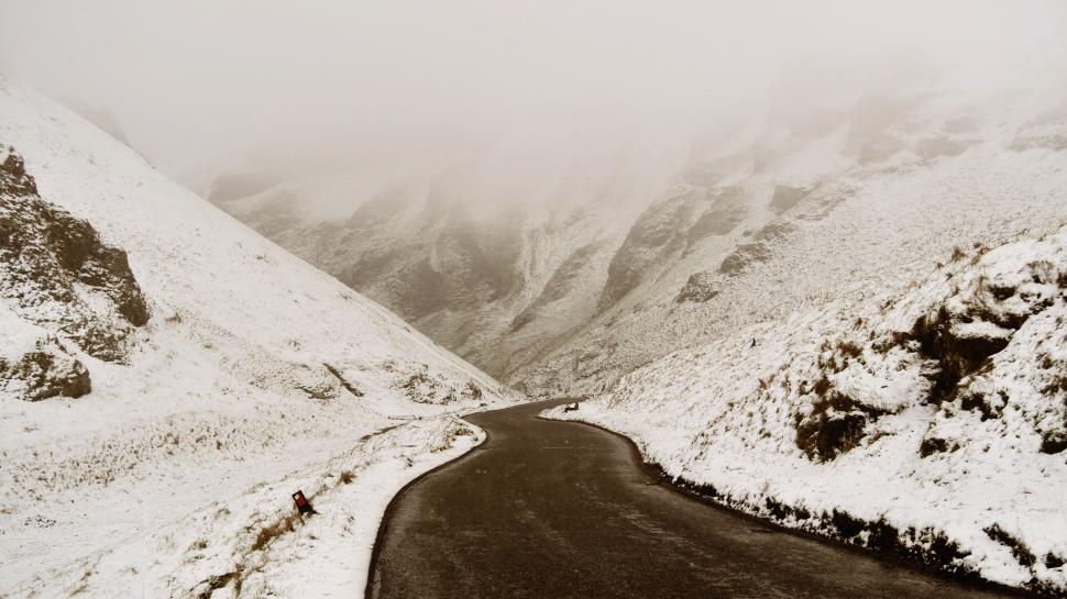 Free Image of Snow-covered road winding through mountains 