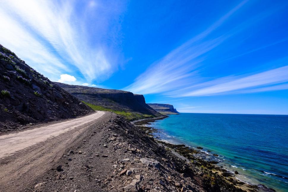 Free Image of Coastal road curving beside a blue ocean 