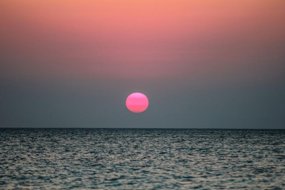 Free Image of Vibrant ocean sunset with red sun 