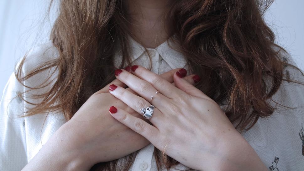 Free Image of Woman with hands over heart, red nails 