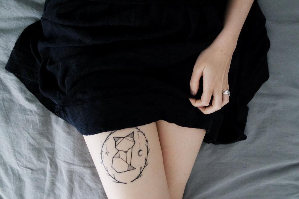 Free Image of Leg with geometric tattoo and black dress 