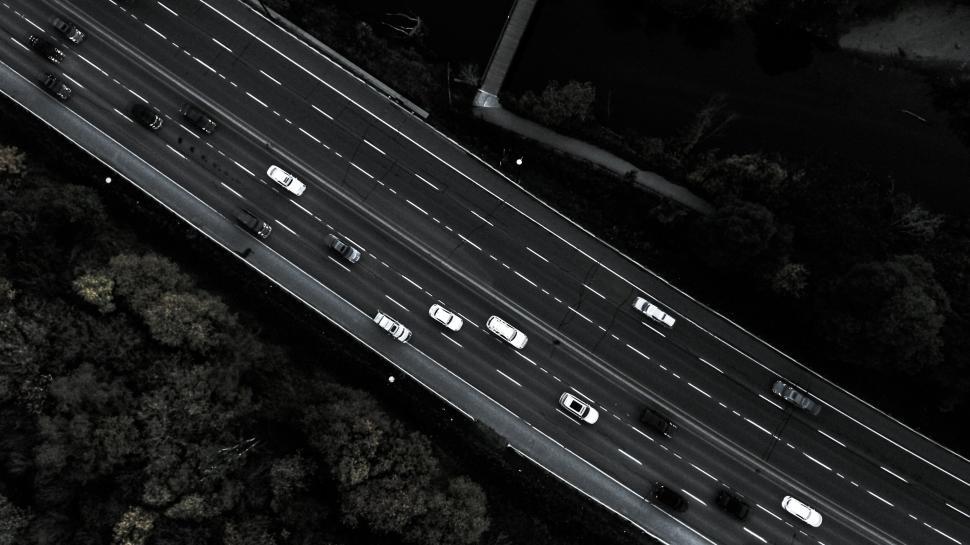 Free Image of Overhead shot of highway traffic surrounded by trees 