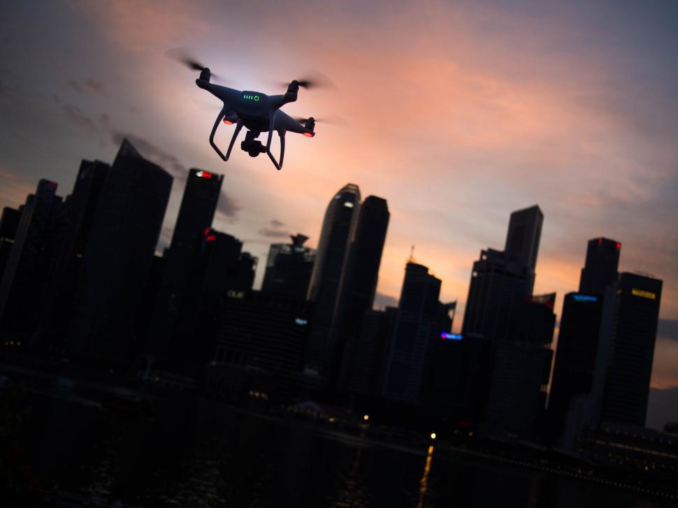 Free Image of Drone flying over city skyline at dusk 