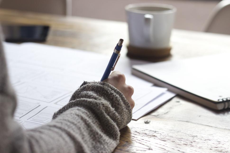 Free Image of Person writing with a blue pen on paper 