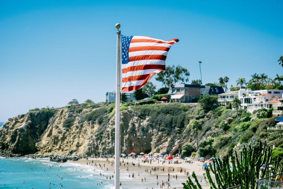 Free Image of American flag waving on a sunny beach 