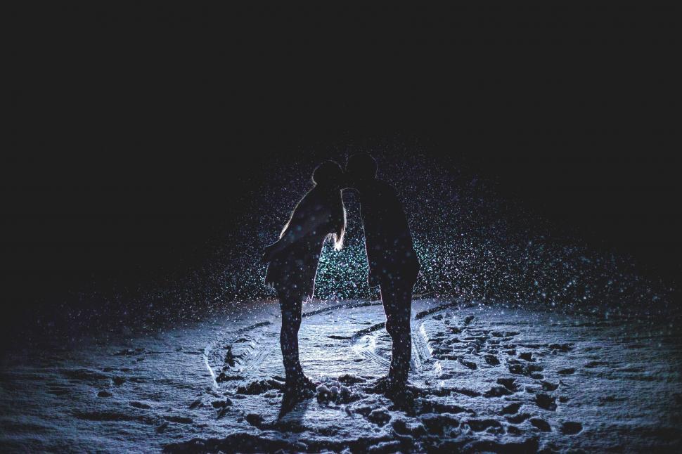 Free Image of Silhouette of two people kissing at night 