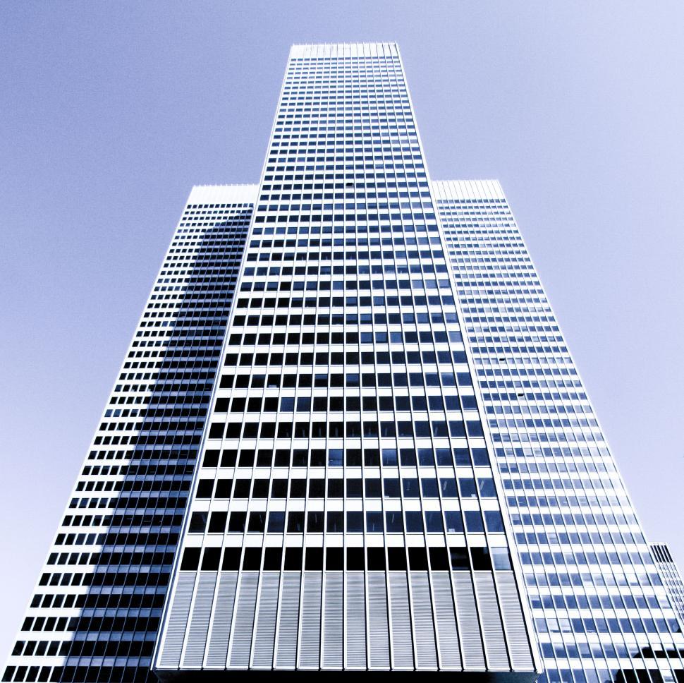 Free Image of Symmetrical blue skyscraper against sky 