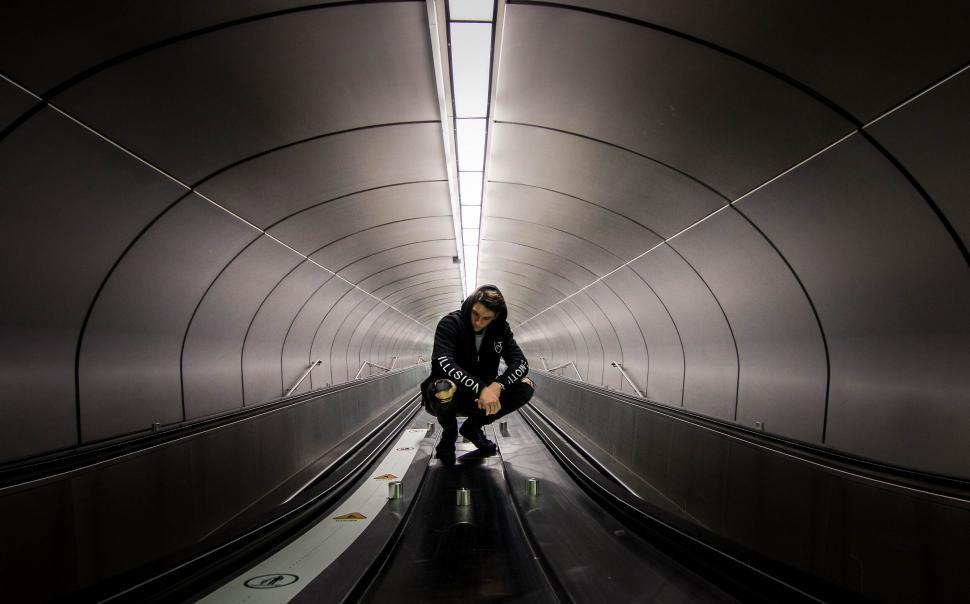 Free Image of Person on escalator in a tunnel-like structure 