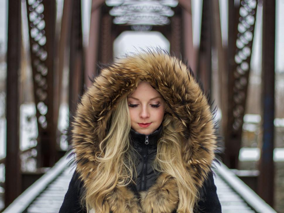Free Image of Young woman with furry hood in snowy landscape 