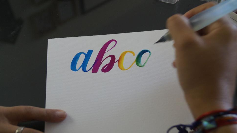 Free Image of Hand writing colorful letters with a brush pen 