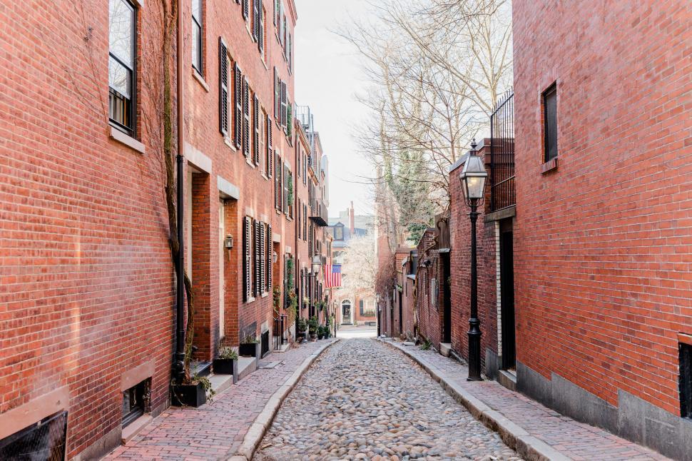 Free Image of Cobbled alleyway between brick buildings 