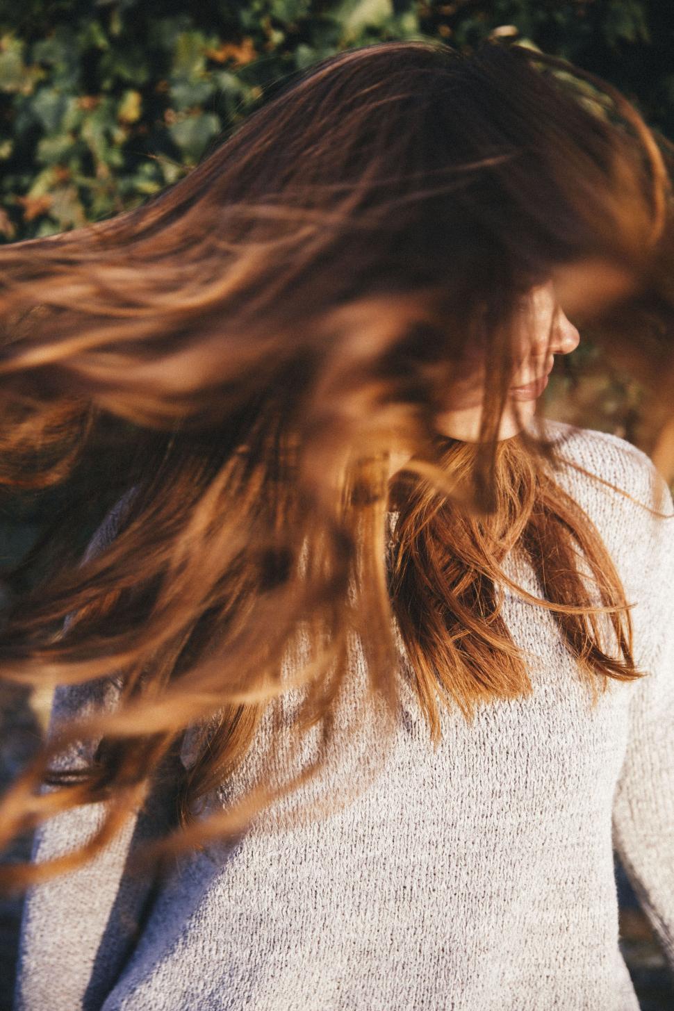 Free Image of Hair flowing in the breeze, woman obscured 