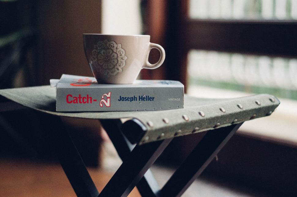 Free Image of Cozy coffee cup on a book on table 