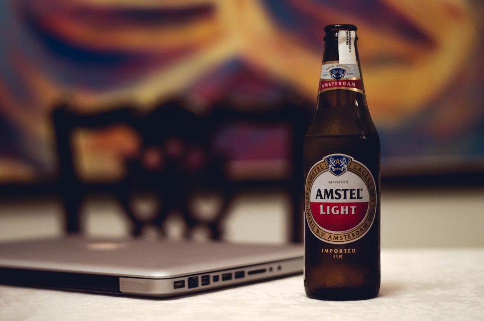 Free Image of Amstel Light beer with laptop in background 