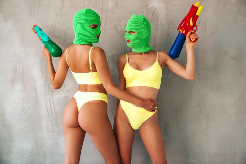 Free Image of Two women wearing ski masks and holding water guns 