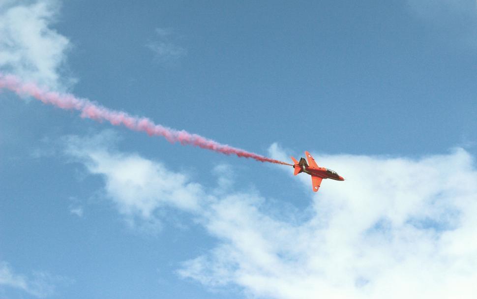 Free Image of Red aerobatic plane with smoke trail 