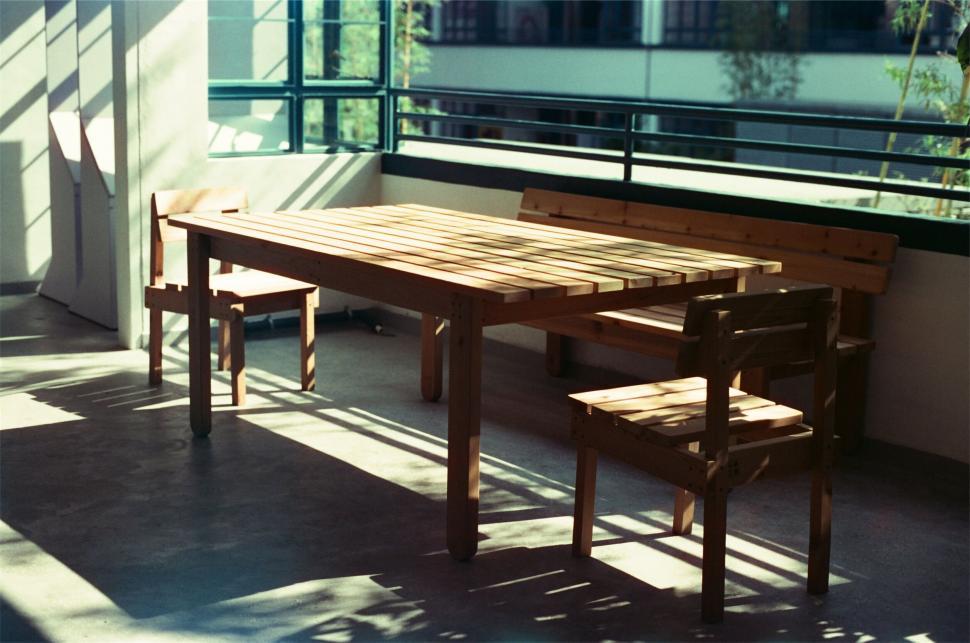 Free Image of Sunlit wooden table and chairs arrangement 