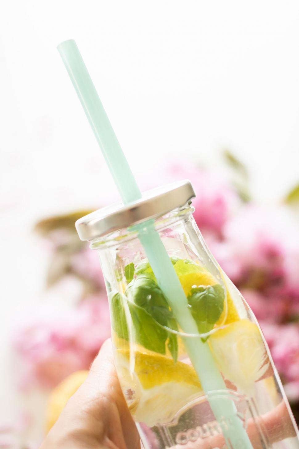 Free Image of Hand holding jar with citrus-infused water 