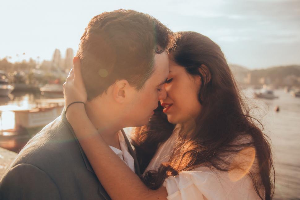 Free Image of Couple kissing with blurred faces at sunset 
