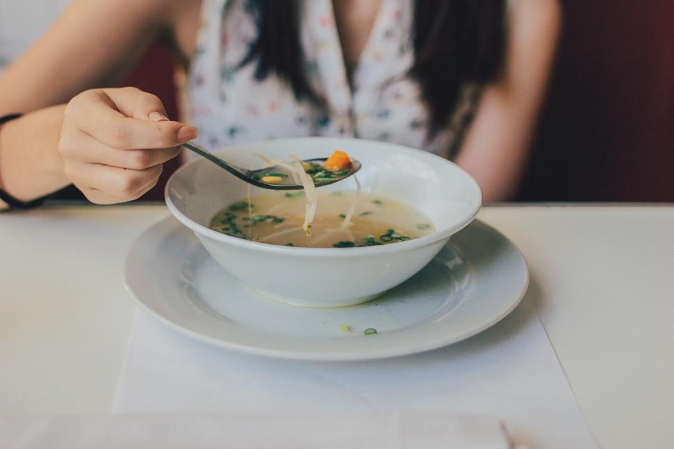 Free Image of Woman eating soup at a restaurant 