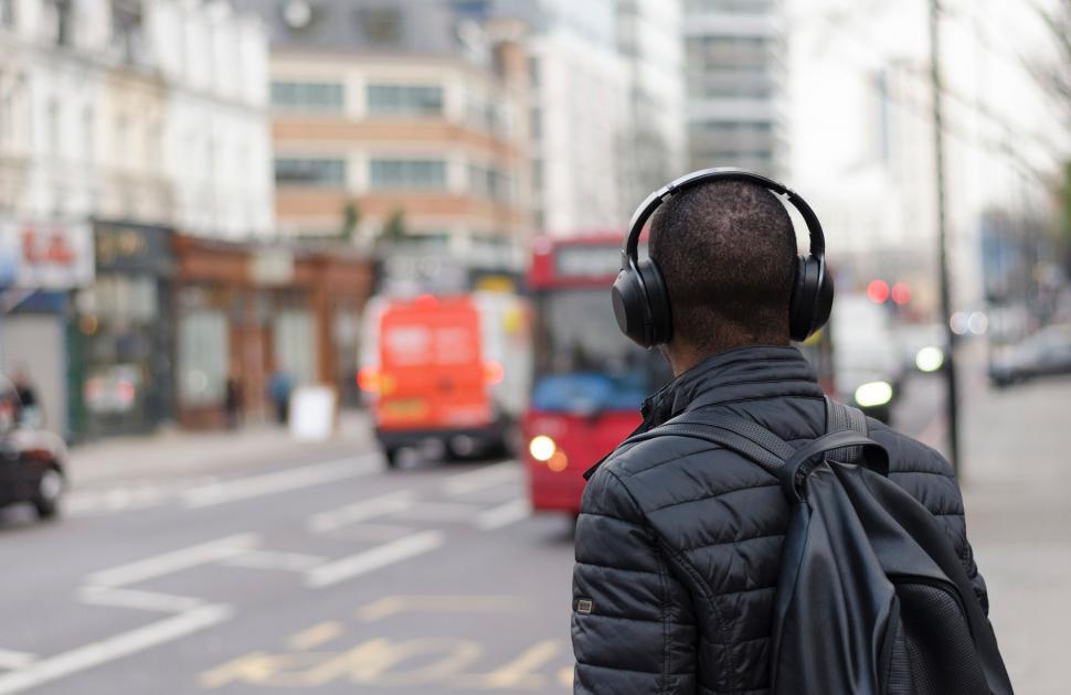 Free Image of Person walking on city street with headphones 
