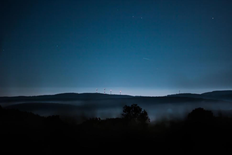 Free Image of Starry night over misty hills 