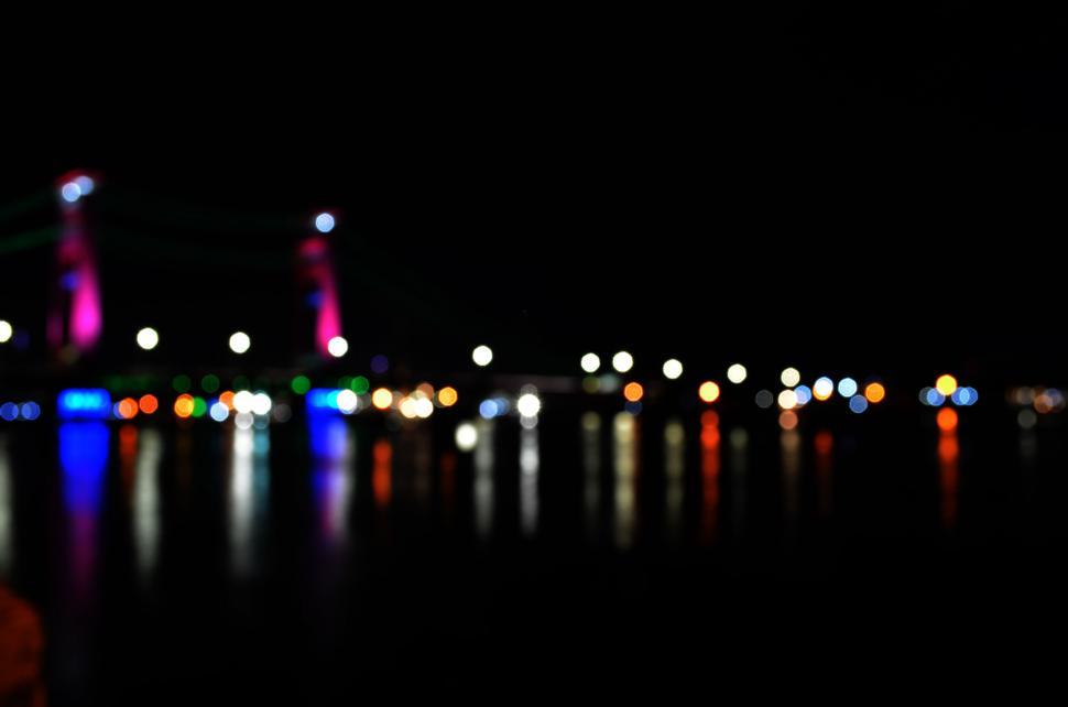Free Image of Blurred city lights reflecting on water 