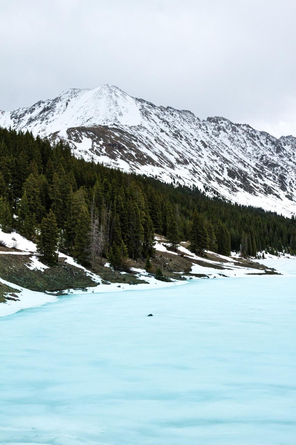 Free Image of Frozen alpine lake with snow-capped mountains 