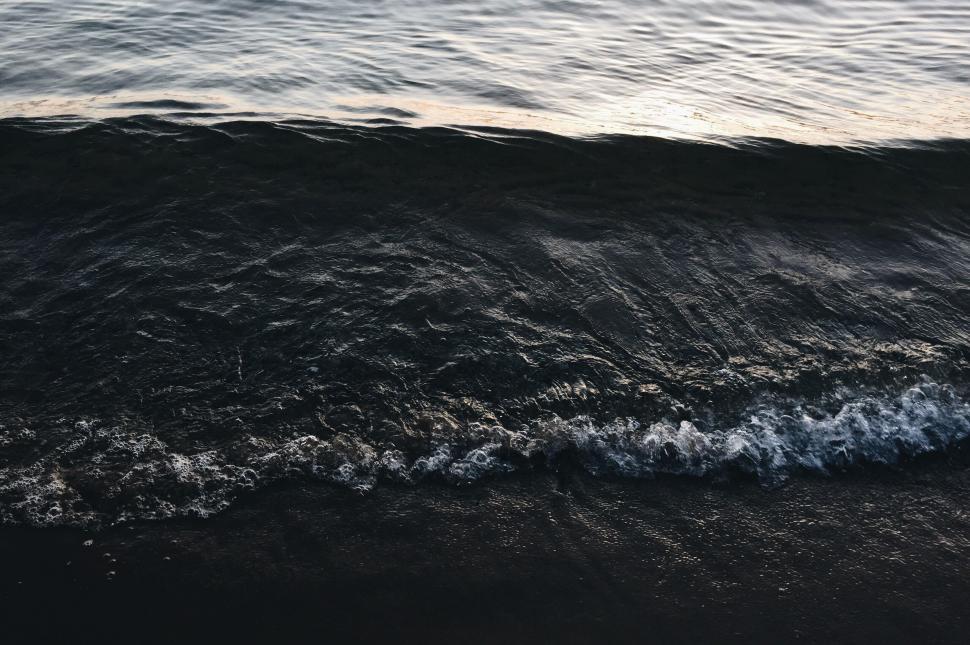 Free Image of Close-up wave on a sandy shore at sunset 