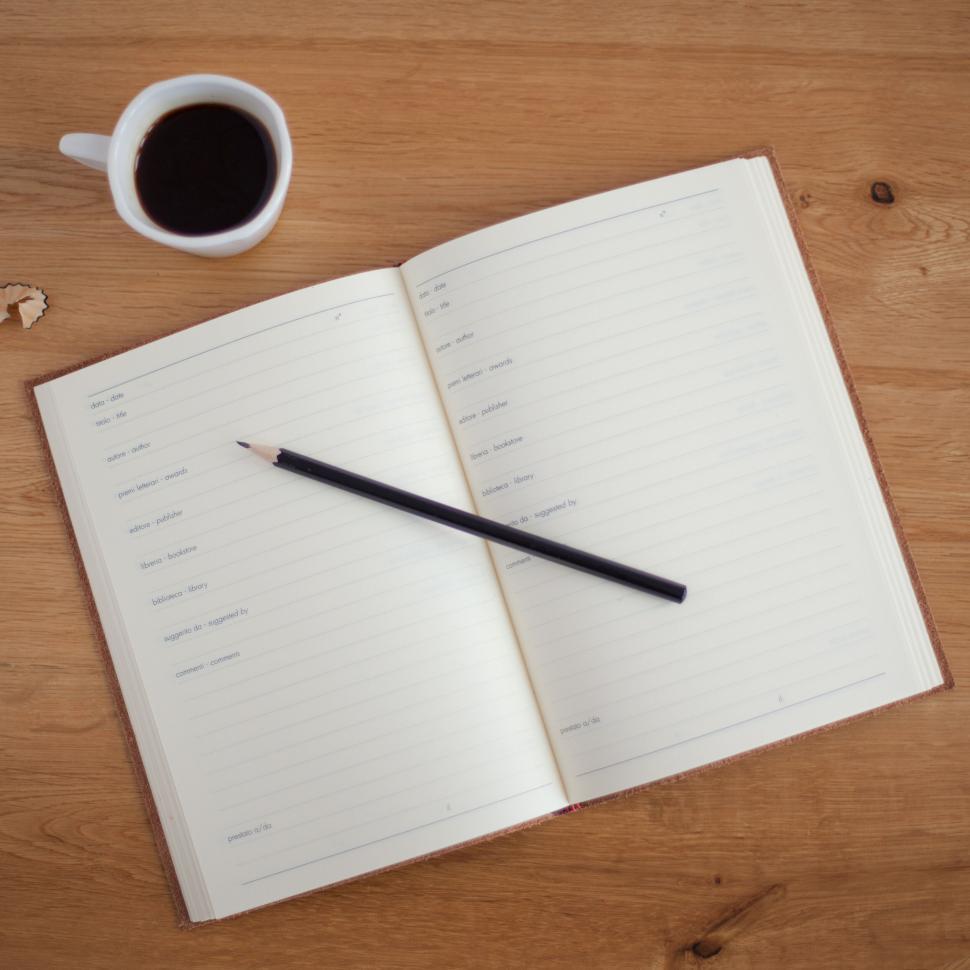 Free Image of Open planner on a wooden table with coffee 