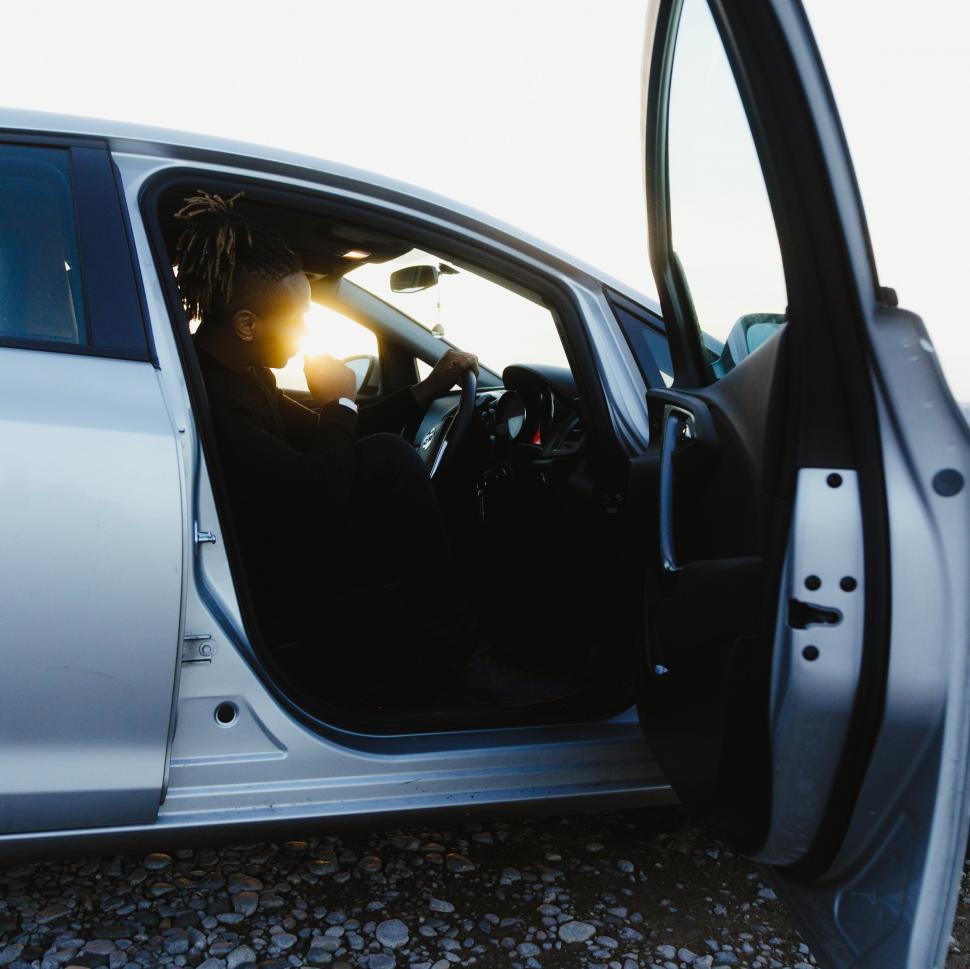 Free Image of Person sitting in a car with door open 