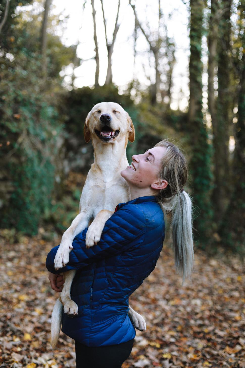 Free Image of Person holding a dog up in the woods 