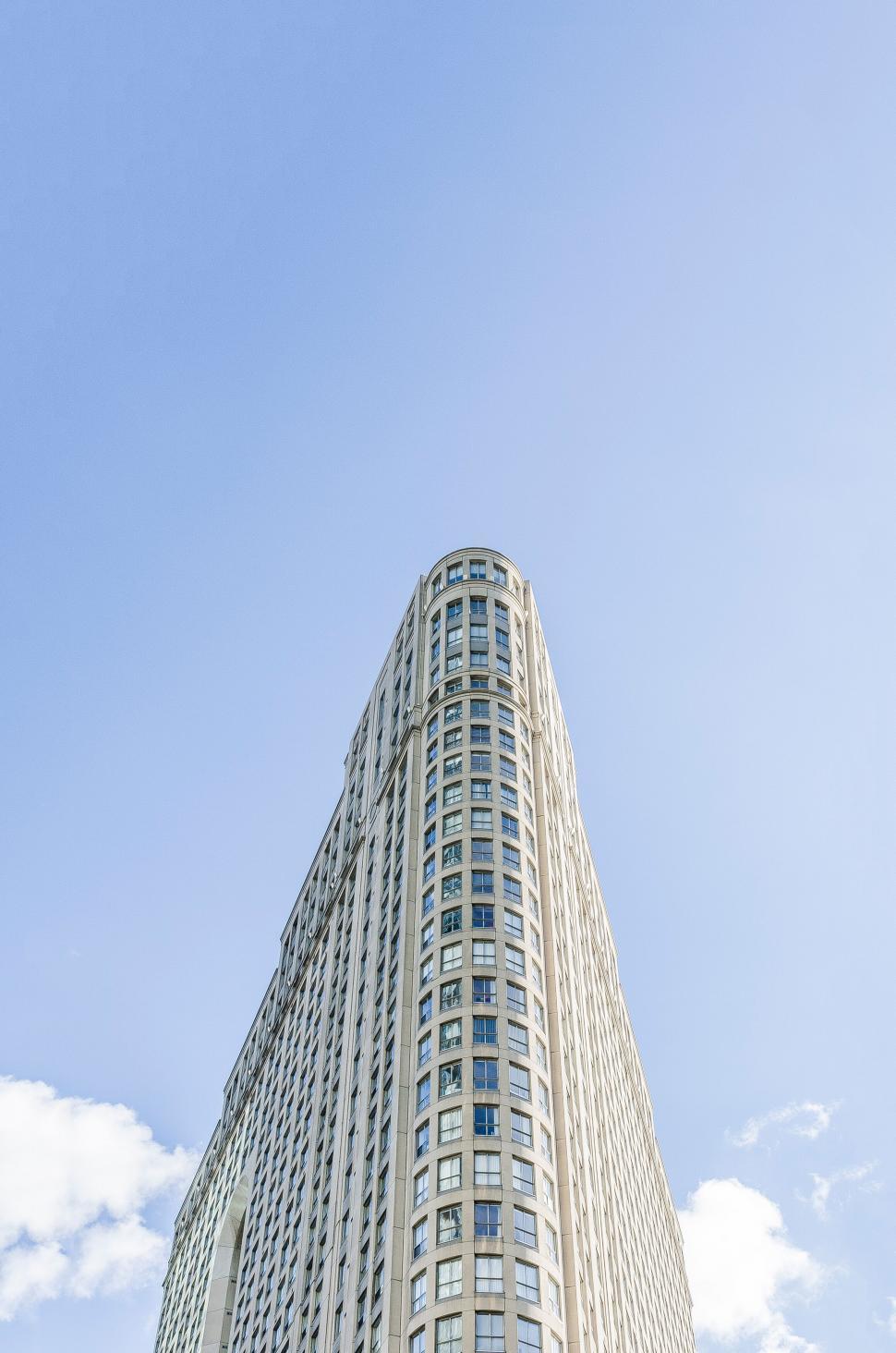 Free Image of Skyscraper against blue sky with clouds 