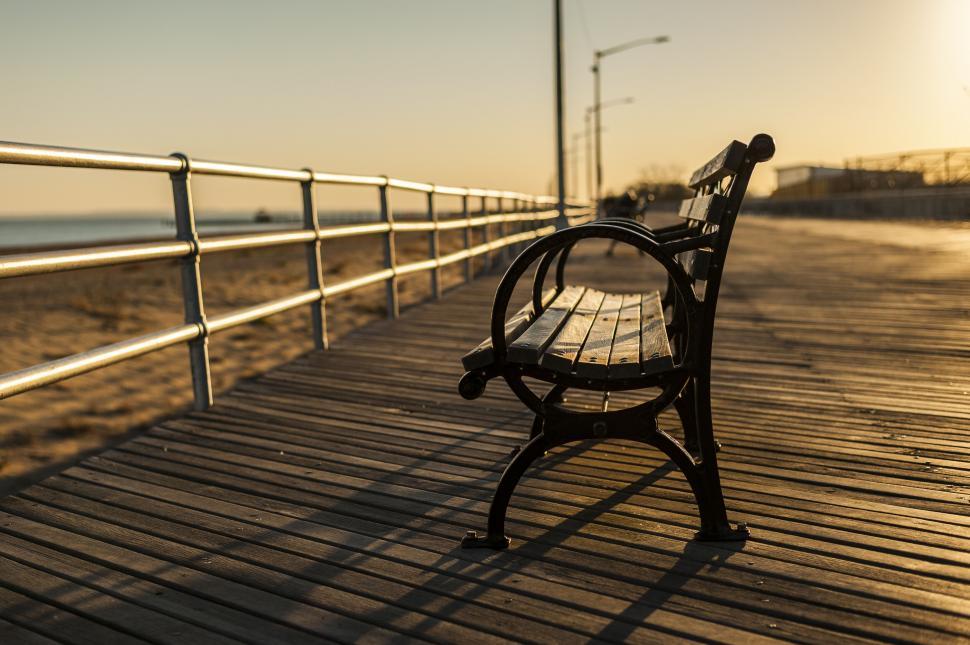 Free Image of Bench on a tranquil boardwalk at sunset 