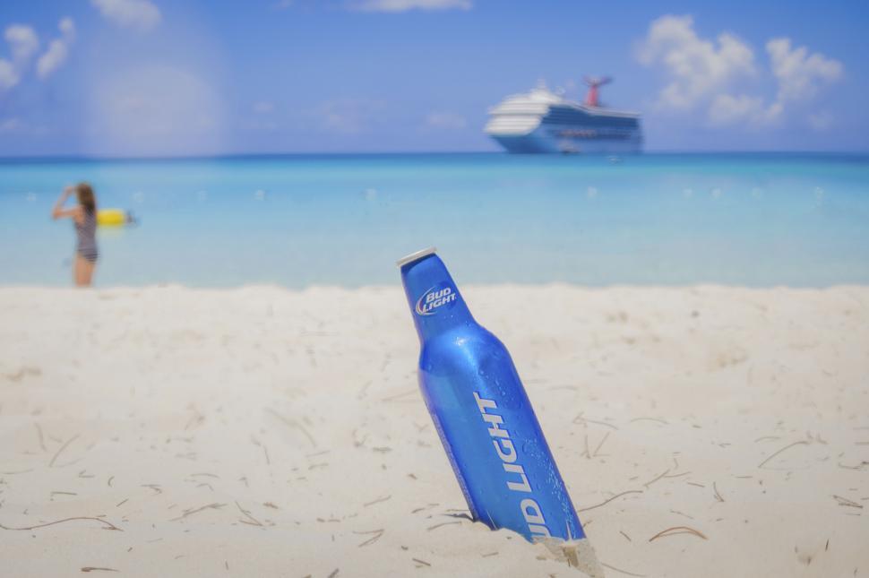 Free Image of Bottle in focus with blurred cruise ship 