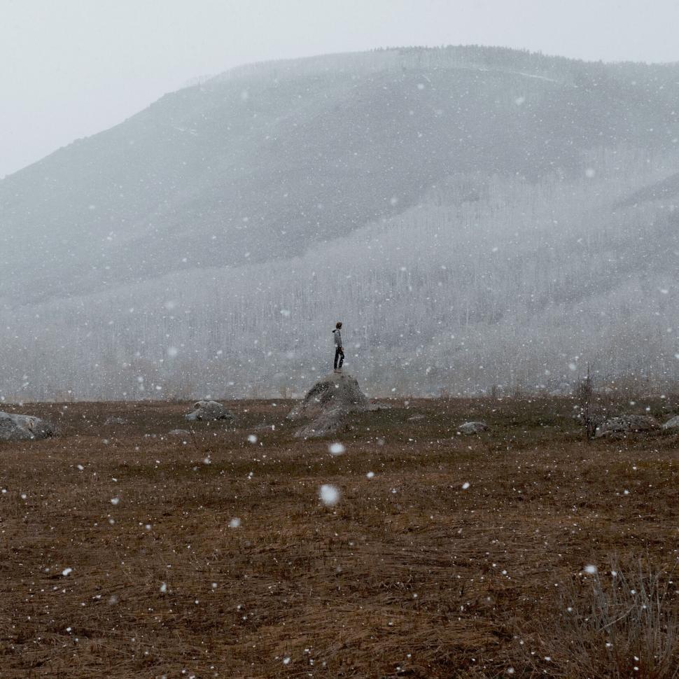 Free Image of Person in snowy landscape with hill 