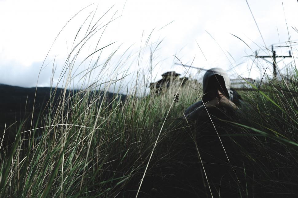 Free Image of Person lying in tall grass with blurred face 