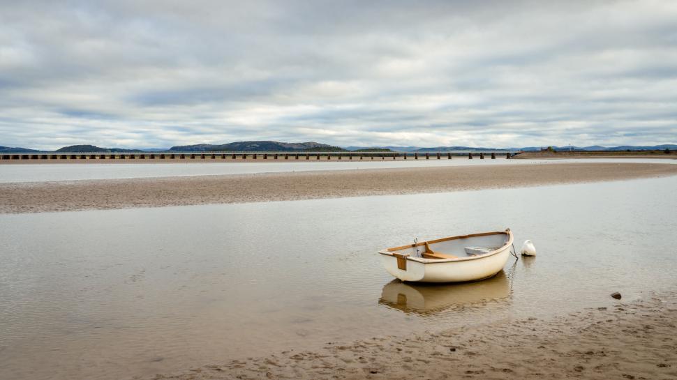 Free Image of Lonely boat in still waters and cloudy sky 