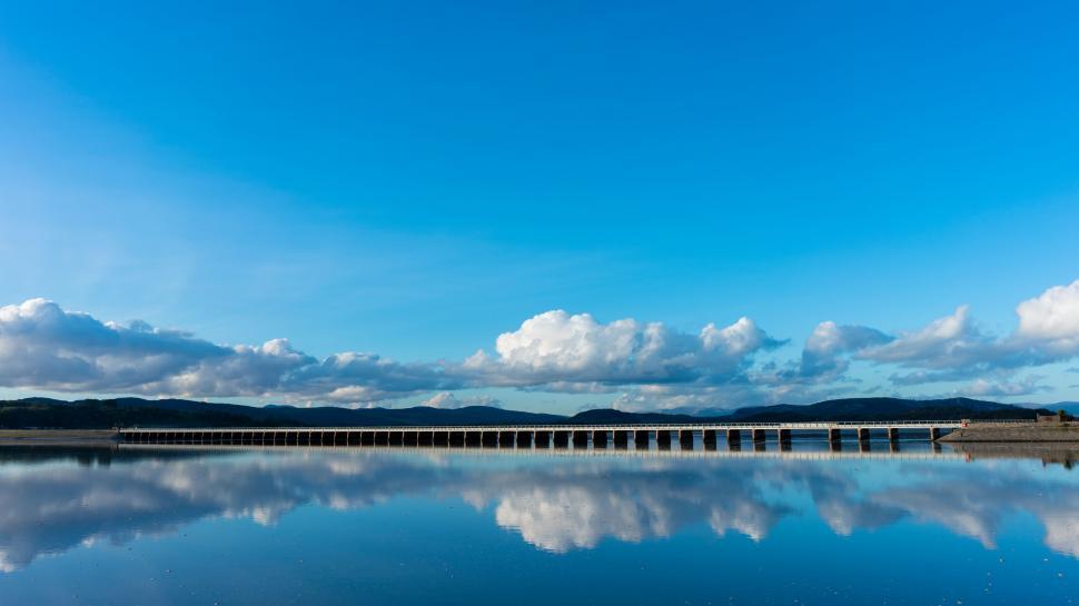 Free Image of Calm lake with clear blue sky and reflections 