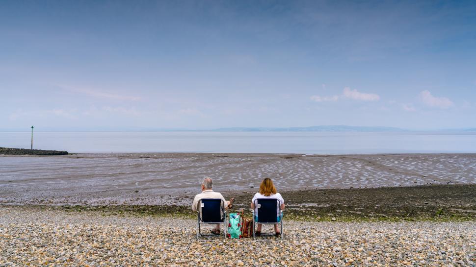 Free Image of Two people sitting by the seaside 